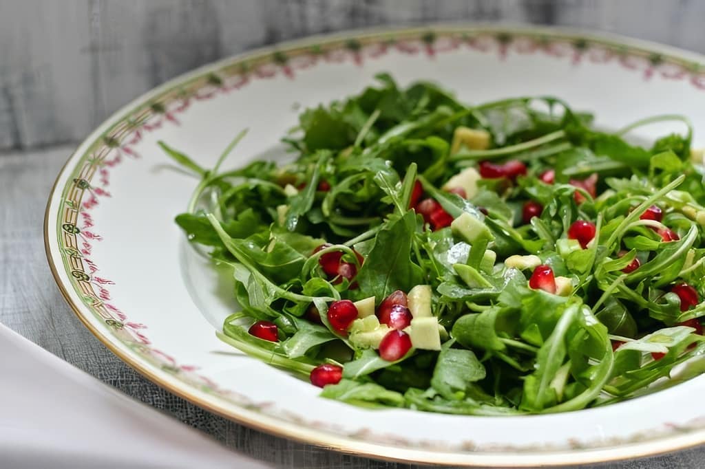 insalata con rucola e metà avocado a dadini e melograno
