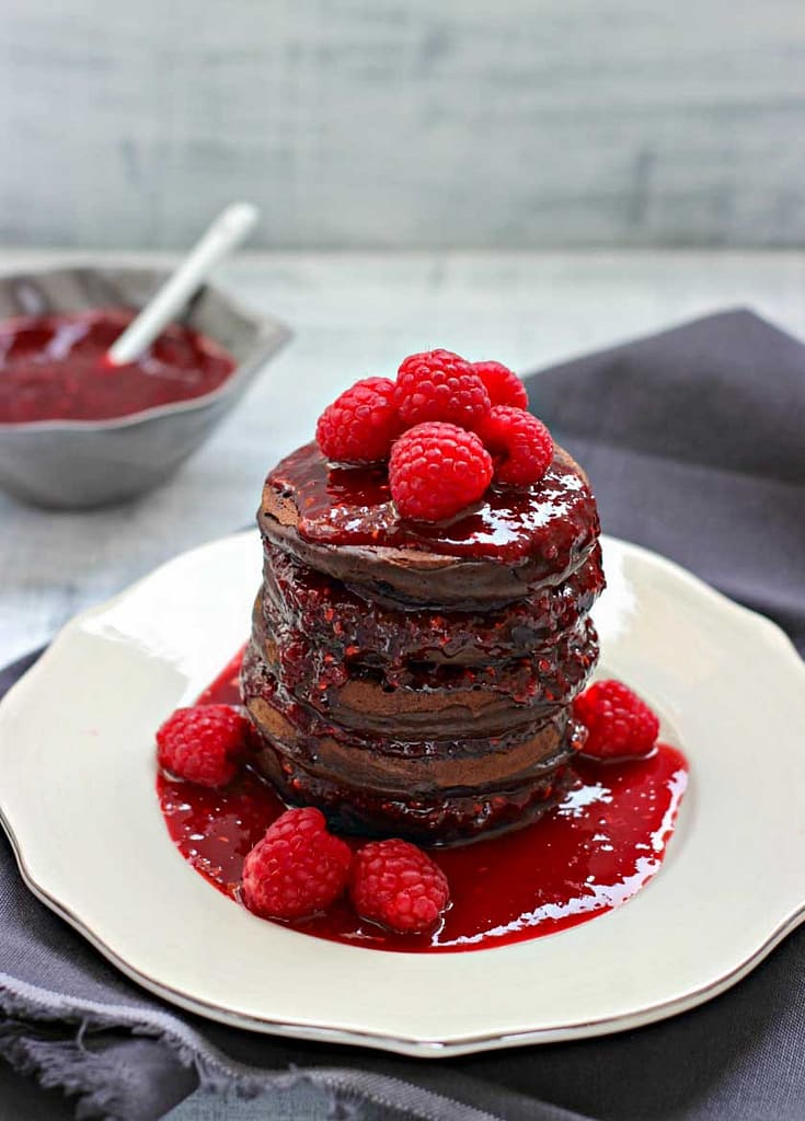 PANCAKES AL CIOCCOLATO CON SALSA DI SCIROPPO D'ACERO E LAMPONI PANCAKES AL CIOCCOLATO CON SALSA DI SCIROPPO D'ACERO E LAMPONI